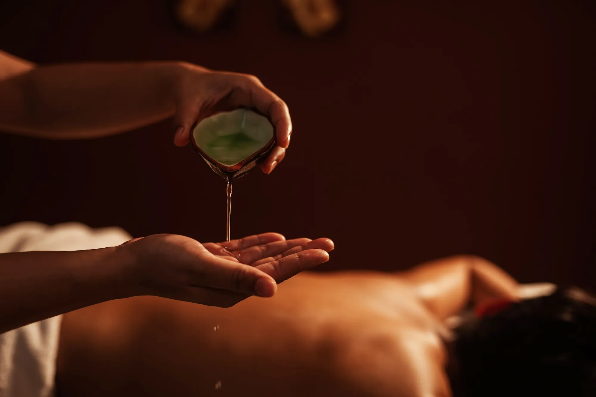 Warm massage oil being prepared for a Senses treatment